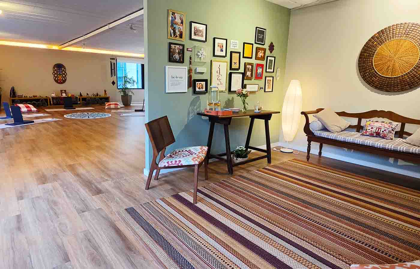 Sala do Espaço Helena com piso de madeira, tapetes e parede de quadros